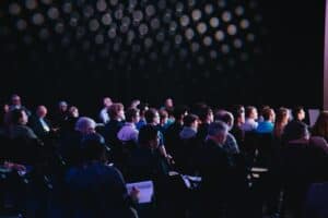 crowd of people sitting on chairs inside room